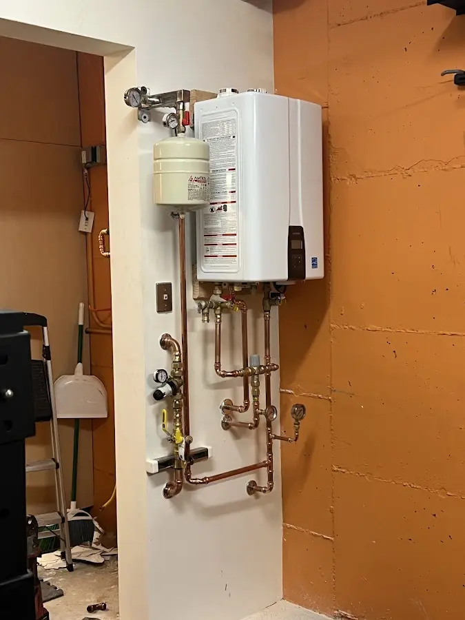 Plumbing technician inspecting water heater connections in Milwaukee